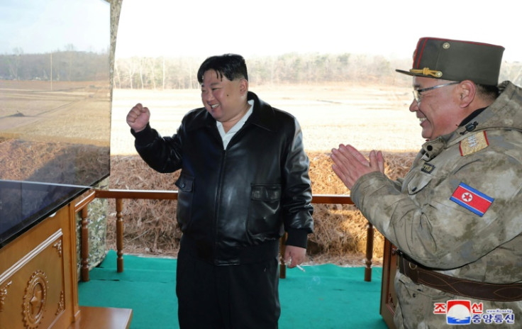 North Korean leader Kim Jong Un (L) attending an ultra-large rocket firing drills, released by state-run news agency KCNA on March 19