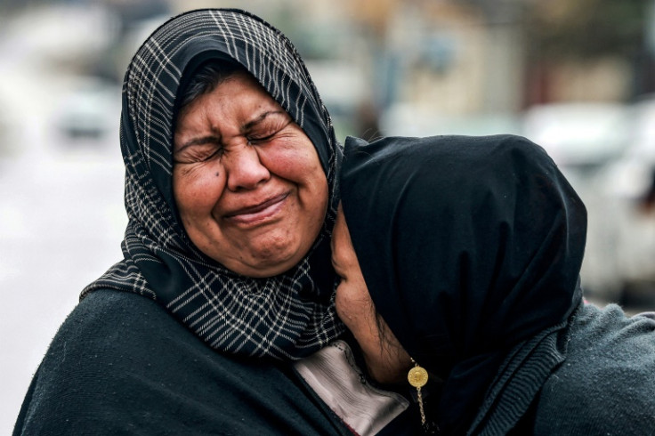 Two women embrace as they react while mourning relatives killed in Gaza