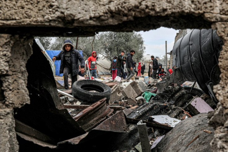 Displaced Palestinians inspect the damage to their tents following overnight Israeli bombardment in Rafah