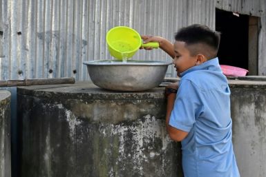 A young boy collects fresh water from a tank in Ben Tre province, where some are now forced to buy water for even domestic needs