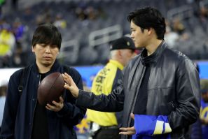 Baseball star Shohei Ohtani talks with his interpreter Ippei Mizuhara before an NFL football game between the New Orleans Saints and the Los Angeles Rams at SoFi Stadium