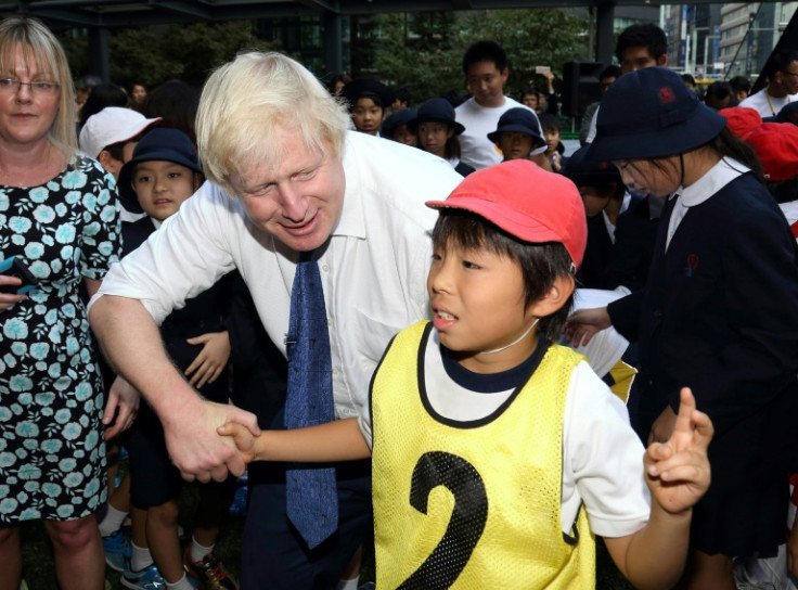 Britain's Boris Johnson (L) collided with this 10-year-old during a rugby game in Tokyo