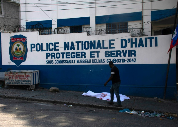 A man walks past the body of a police officer killed amid ongoing gang violence in Port-au-Prince, Haiti, on March 20, 2024