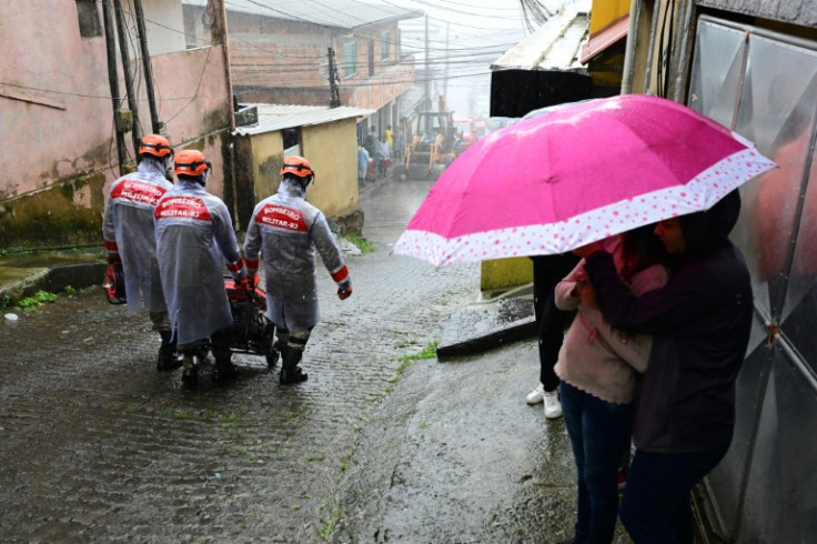 Firefighters move a generator in Petropolis, Brazil