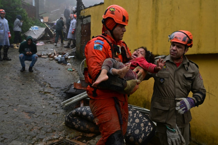 Rescuers carry a girl, who had been trapped for hours  under the rubble of her house that was destroyed by heavy rains in Petropolis, Brazil, on March 23, 2024