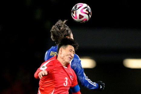 North Korean defender Jang Kuk Chol (front) and Japan's Ayase Ueda battle for the ball