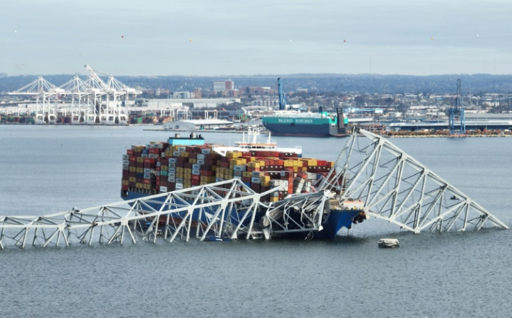 In this aerial image, the steel frame of the Francis Scott Key Bridge sits on top of a container ship after the bridge collapsed in Baltimore, Maryland on March 26, 2024