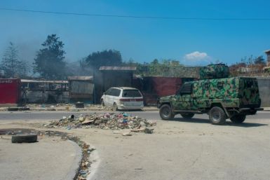 A police vehicle patrols an area that was set fire to by armed gangs in Port-au-Prince, Haiti