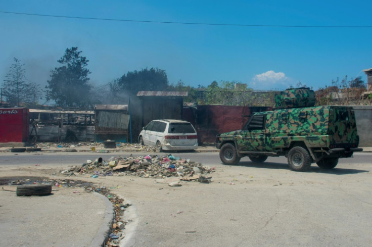 A police vehicle patrols an area that was set fire to by armed gangs in Port-au-Prince, Haiti