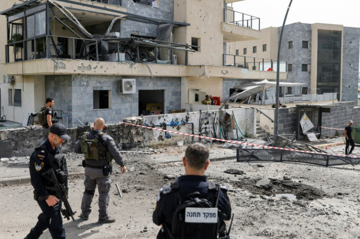 Isreli security forces inspect the area of the border town of Kiryat Shmona where a suspected Hezbollah rocket killed a civilian