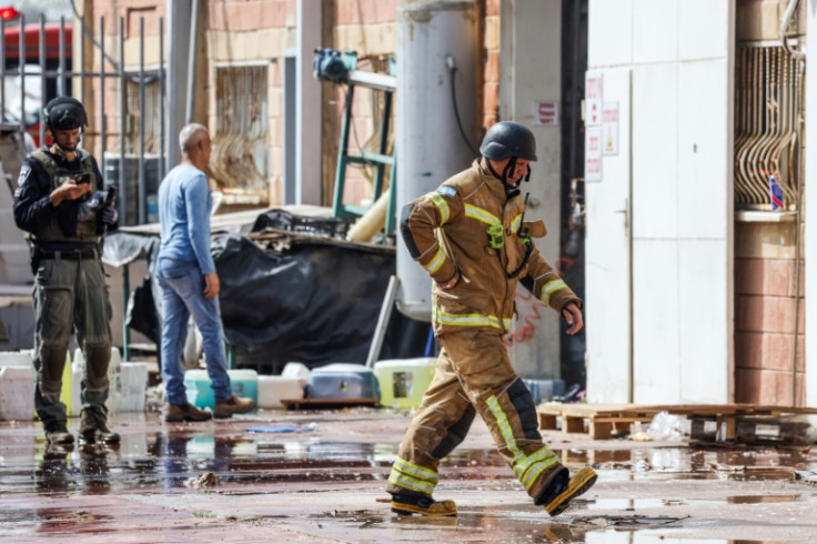 Israeli firefighters work on a factory building that hit was by a Hezbollah rocket in Kiryat Shmona in northern Israel near the Lebanon border, on March 27, 2024