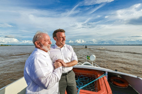 Brazil President Lula and French President Emmanuel Macron hold hands as they share a bilateral meeting while sailing at Guajara Bay off Belem, Brazil, on March 26, 2024 in this handout image from the Brazilian presidency