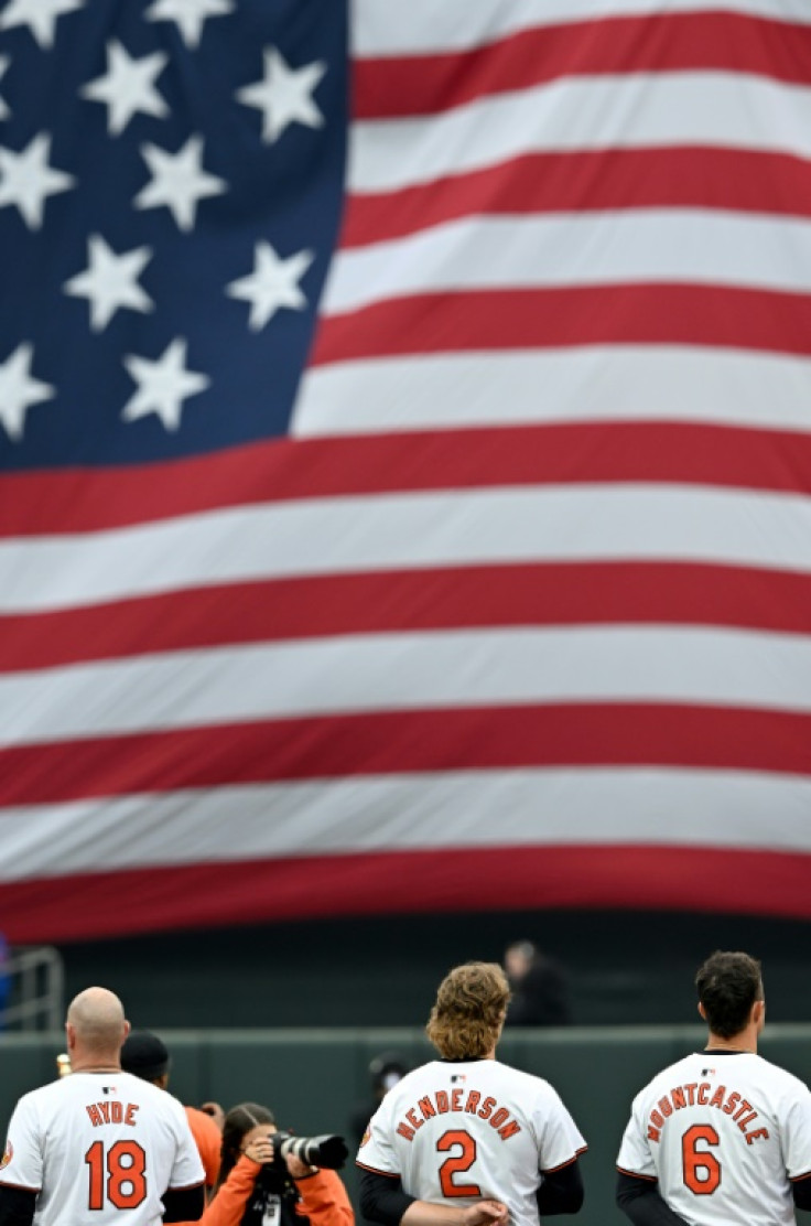 The Baltimore Orioles stand for the national anthem before their Major League Baseball home opener against the Los Angeles Angels