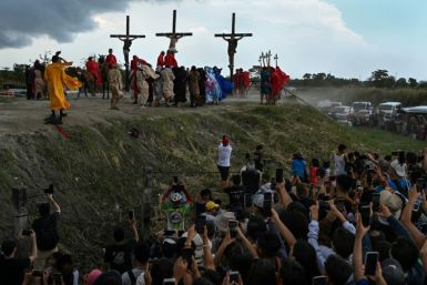 People watch the re-enactment of the crucifixion of Jesus Christ on Good Friday in San Fernando, north of the Philippine capital Manila