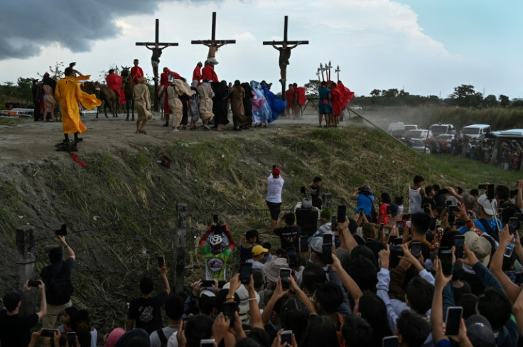 People watch the re-enactment of the crucifixion of Jesus Christ on Good Friday in San Fernando, north of the Philippine capital Manila