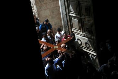 Christian pilgrims carry a wooden cross on the Good Friday procession through the streets of the Old City of Israeli-annexed east Jerusalem