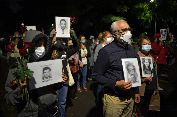 People holding pictures of persons who were killed or went missing during the 1964-1985 dictatorship, demonstrate on the 58th anniversary of the military coup at Ibirapuera Park, in Sao Paulo, Brazil, on March 31, 2022