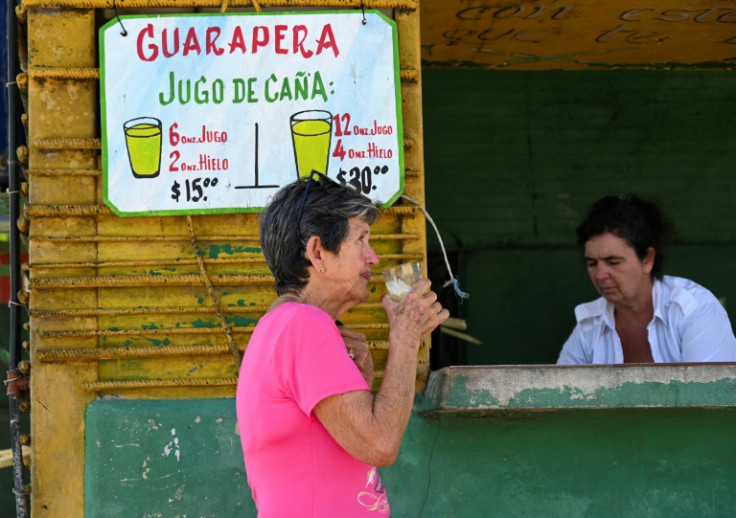 A woman sips sugar cane juice in Havana on March 26, 2024
