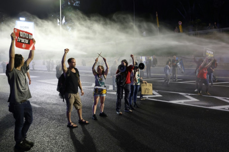 Israeli police target protesters with water cannon as they block a road in front of the Defense Ministry in Tel Aviv, on March 30, 2024