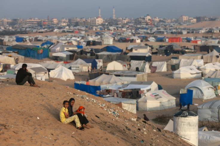 Palestinian children sit on a hill next to tents housing the displaced in Rafah in the southern Gaza Strip on March 30, 2024