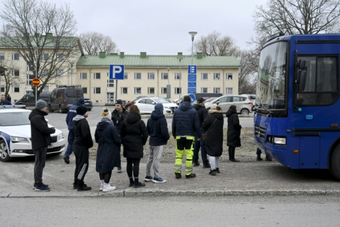 Finnish police officers talk to family members of pupils at the primary Viertola comprehensive school