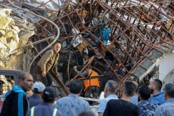 Emergency and security personnel inspect the wreckage of the Iranian consular annex in Damascus after it was hit by an air strike officials blamed on Israel