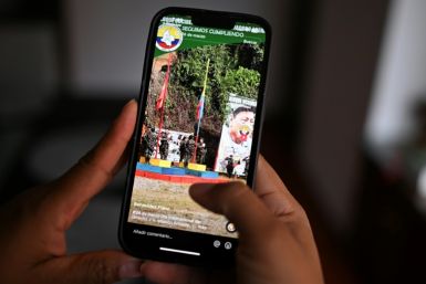 A woman looks at the Tik Tok account of a dissident FARC guerrilla faction