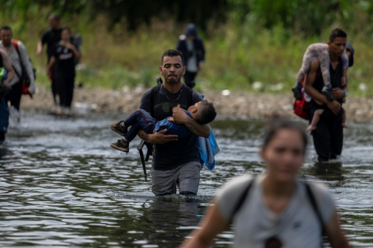 Migrants cross the Tuquesa river near Bajo Chiquito village, the first border control of the Darien Province in Panama, on September 22, 2023