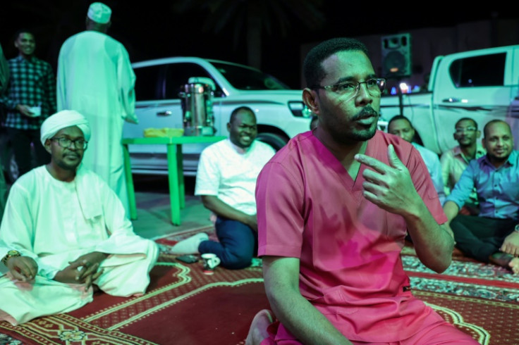 Essam Yusuf sits with others to break their fast during the holy Muslim month of Ramadan