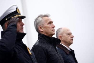 NATO Secretary General Jens Stoltenberg (C), flanked by the Chair of NATO's Military Committee Admiral Rob Bauer (L), and NATO Deputy Secretary General Mircea Geoana (R) attend a wreath laying ceremony for the alliance's 75th anniversary in Brussels