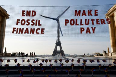 Activists demonstrate in Paris against fossil finance, with the Eiffel Tower in background, on June 21, 2023