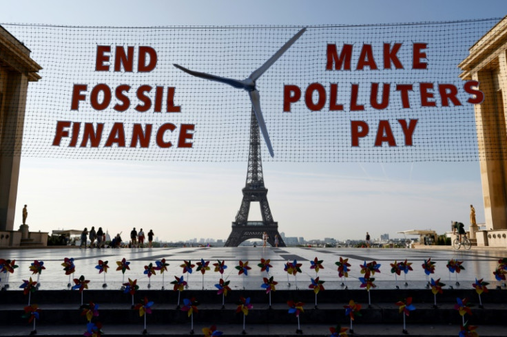 Activists demonstrate in Paris against fossil finance, with the Eiffel Tower in background, on June 21, 2023