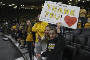Young fans hold up signs thanking Caitlin Clark at a game in Iowa