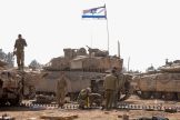 Israeli soldiers work on their tanks in a army camp near Israel's border with the Gaza Strip on April 8, 2024