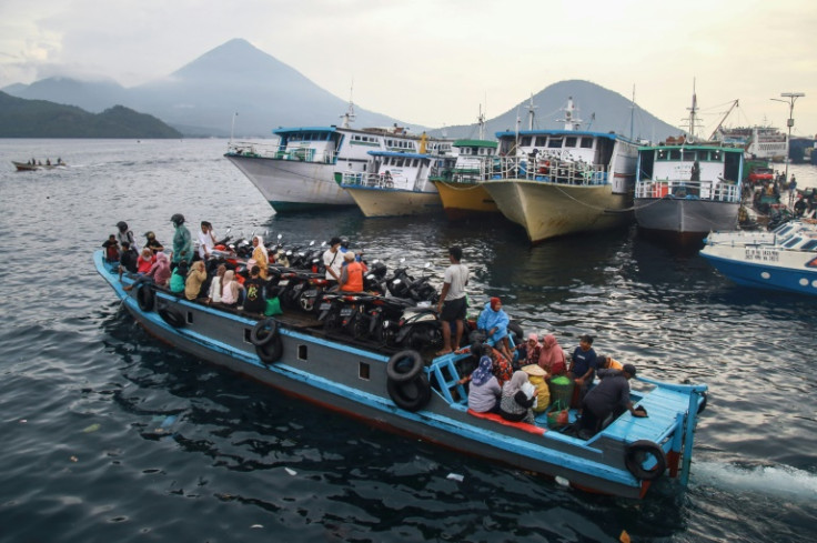 People travel on a wooden boat with motor scooters ahead of Eid al-Fitr, which marks the end of the Muslim fasting month of Ramadan