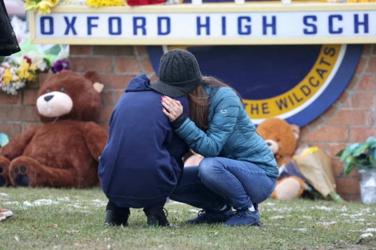 People embrace as they visit a makeshift memorial outside Oxford High School, where Ethan Crumbley shot dead four fellow students