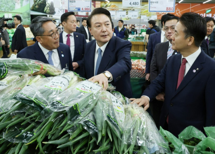 South Korean President Yoon Suk Yeol (C) commented on the price of green onions while visiting a market earlier this year, unwittingly handing his opponents a campaign trail cudgel