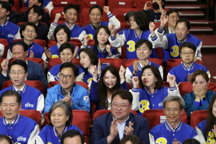 Candidates of Minjoo Union, the affiliated party of Lee Jae-myung's opposition Democratic Party, watch TVs broadcasting exit poll results