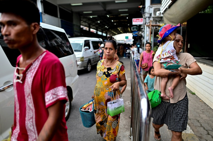 Myanmar nationals cross over into Thailand at the Tak border checkpoint in Thailand's Mae Sot district