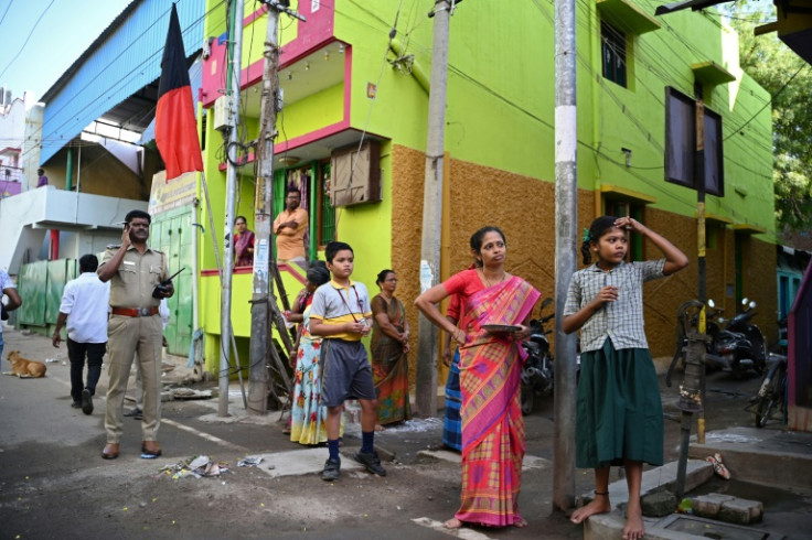 Residents of Madurai watch and wait for a candidate campaigning ahead of India's general election