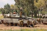 Israeli soldiers gather around army tanks stationed in an area along the border with the Gaza Strip in southern Israel on April 10, 2024