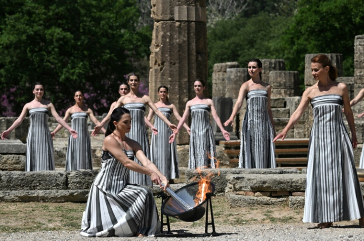 Greek actress Mary Mina, playing the role of the High Priestess, lights the torch during the rehearsal of the flame lighting ceremony