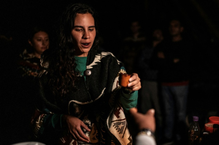 A woman prepares to drink yage or ayahuasca during a ceremony with Colombian shaman Claudino Perez