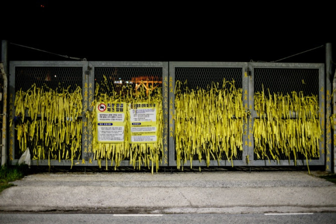 Yellow ribbon dedications are displayed on the main gates at a port in Mokpo, South Jeolla Province, near to where the salvaged Sewol ferry stands