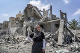A woman stands amid rubble in the Maghazi camp for Palestinian refugees in the central Gaza Strip on April 15, 2024