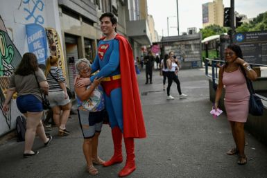 Leonardo Muylaert, 36, known as the Brazilian Superman, poses for a picture with a woman at the Saens Pena Square in the Tijuca neighborhood in Rio de Janeiro