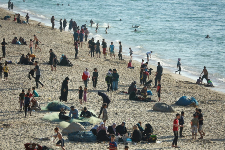 Children paddled in the sea and their friends played ball games on the sand  -- but Gaza's war was never far away