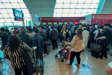 Passengers queue at a flight connection desk at Dubai airport