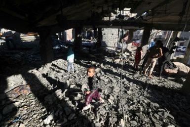 Palestinian children walk inside a building destroyed by Israeli bombardment in Rafah
