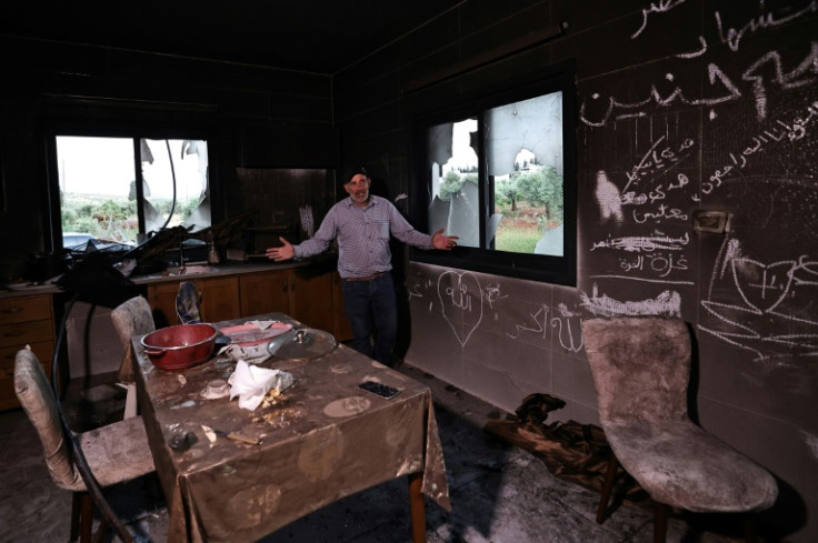 A Palestinian man stands inside his kitchen in the aftermath of an attacked by Israeli settlers